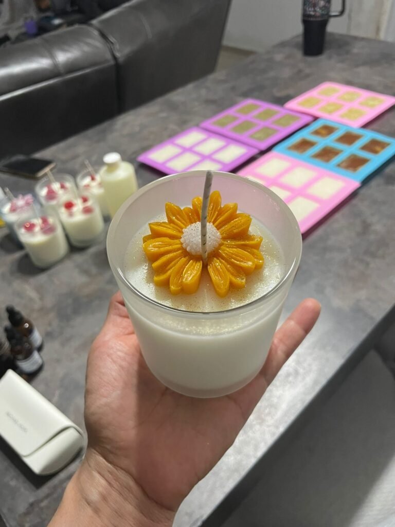 Vela artesanal blanca decorada con un girasol de cera