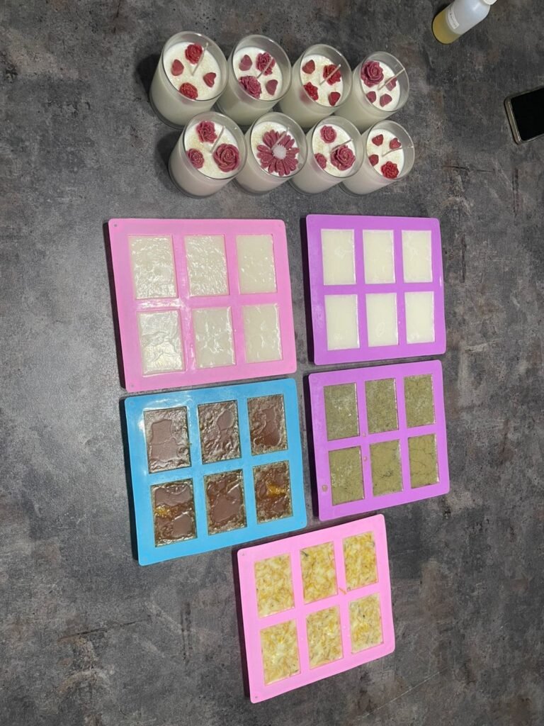 Moldes con jabones en proceso y velas con flores