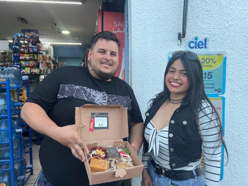 Clientes sonrientes con una caja de jabones artesanales